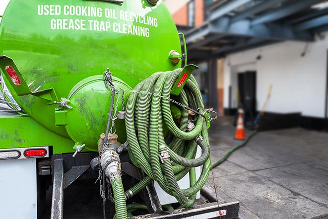 a technician pumping a grease trap in a commercial building in Chester